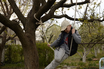 
Spring. Family leisure. A boy plays in a tree, plays sports.