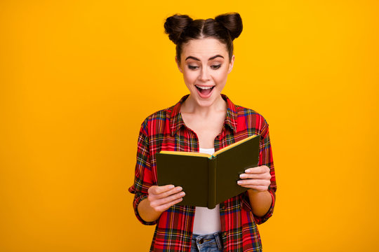 Photo of pretty student lady two cute buns open mouth hold book read interesting adventure story favorite novel wear casual white red plaid shirt isolated yellow color background