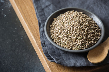 Organic kernels hemp in black bowl. Close up.