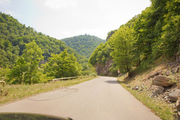 Fototapeta na wymiar Mountain road between forests . Winding mountain road . A road in Azerbaijan between Forest . Empty road in mountainous area along mountains . highway and mountain with beautiful clouds landscape.
