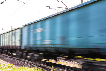 Train with freight wagons in motion on electrified railway