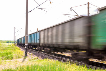 Train with freight wagons in motion on electrified railway