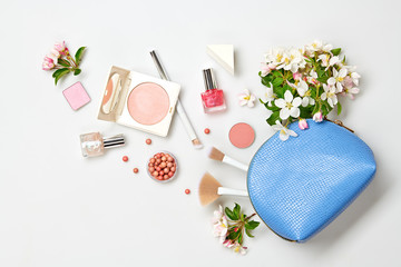 Beauty cosmetics makeup product flying. Woman make up, brushes lipstick and blossom falling in...