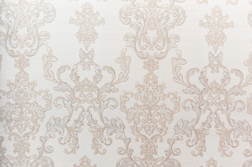 The texture of the Wallpaper. Beige and gold patterns in the form of monograms. Desktop background.