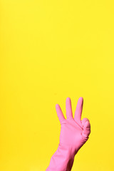 hand with glove and sign ok on yellow background