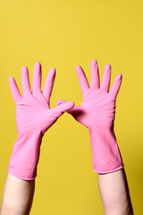 gloved hands raised on yellow background