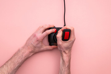 Fototapeta premium Male hand using retro video game joystick controller. Overhead view