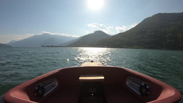 Bow rider boat navigating fast on lake of Lecco, in northern Italy.