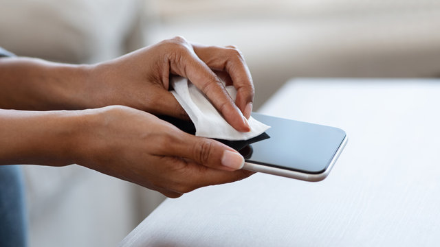 Gadget Disinfection. Unrecognizable Black Woman Disinfecting Smartphone Before Use At Home