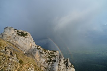 rainbow with rock wall in the foreground and in the background the river Rhine in the valley
