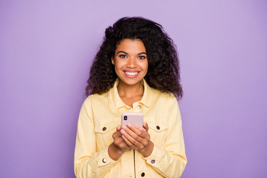 Photo of stylish trendy cheerful toothe beaming girlfriend with phone looking at you cheerfully isolated pastel violet color background