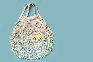 Fototapeta premium white string bag on a blue background, copy space. eco-friendly material - love for the planet