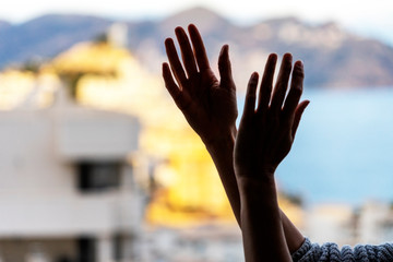 Woman clapping hands, applauding from balcony to support doctors, nurses, hospital workers....