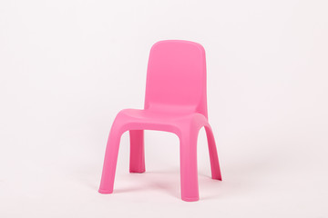 pink plastic childrens chair on white background