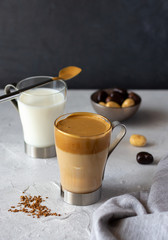 Dalgona coffee, new Korean drink, instant coffee and sugar whipped cream with iced milk. Trendy beverage. Vertical orientation, copy space