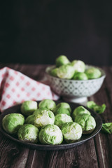 Choux de Bruxelles dans un petit bol céramique posé sur la table en bois en cuisine