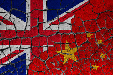 Obraz premium Flags of United Kingdom and China on a cracked wall, dry land. Concept of relationship or conflict between countries