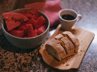 healthy breakfast, with homemade ciabatta bread on a wooden board, blue bowl watermelon and espresso coffee