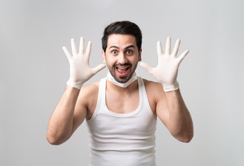 A well prepared man is having a wild smile with face mask and hands glove protect from coronavirus Covid-19 pandemic with copy space, self-quarantine, preparation, panic, prevention, lockdown.