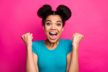 Closeup photo of crazy funky dark skin lady two buns raise fists celebrating amazing success achievement yelling loud wear blue casual t-shirt isolated bright pink color background