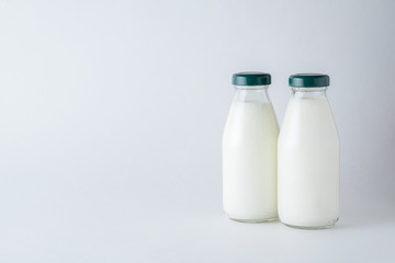 Two glass bottles of homemade kefir on a white background with copy space