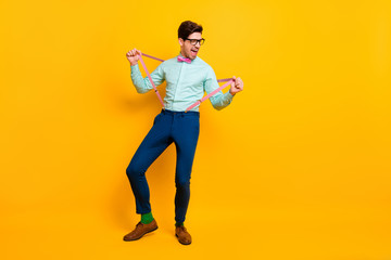 Fototapeta na wymiar Full length photo of cool stylish guy boyfriend hands hold stretch suspenders festive mood scream excited wear specs shirt bow tie trousers shoes isolated vivid yellow color background