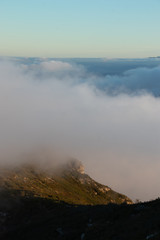 Beautiful sunrise on the mountain peak with clouds passing by