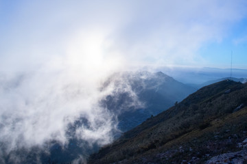 Beautiful sunrise on the mountain peak with clouds passing by