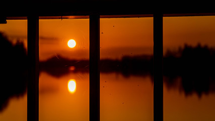 Beautiful sunset with reflections and details of a steel railing near Ettling, Isar, Bavaria,...