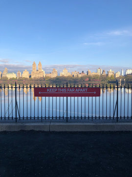 New York, USA. April 2020. Coronavirus Lockdown. Keep This Far Apart Sign Overlooking The Jackie Onassis Reservoir, Central Park Looking Towards The West Side.