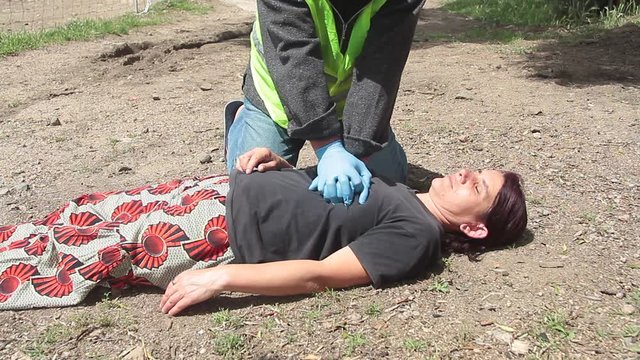  emergency doctor with yellow jacket who intervenes for a resuscitation of a woman with cardiac massage
