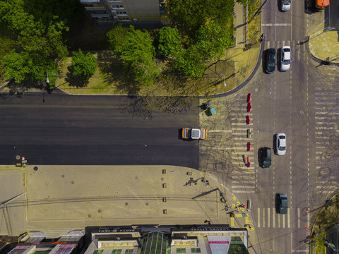 Aerial Top Down View Of Asphalting Construction Works With Commercial Repair Equipment Road Roller Compactor Machine. Contrast Between New And Old Road Surface.