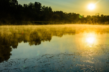 Fototapeta na wymiar Fog above the water surface. Sunrise at river