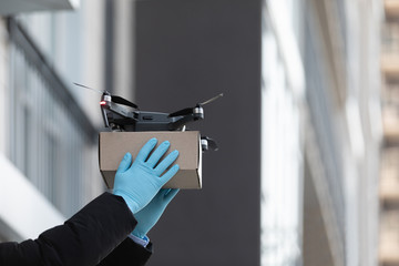 Hands in gloves send a parcel with drone, fast and safe