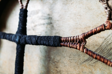 Details of shamanic tambourine. Leather-braided handle, handmade, close-up view.