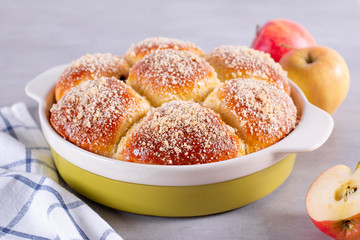 Bun with crumb on a light gray background. Bun sprinkled with crumbs. Fresh tasty bun with crumb.