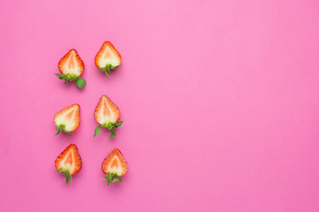 Strawberries isolated on pink background. Fresh berry flat lay. Creative food concept. Copy space, halves