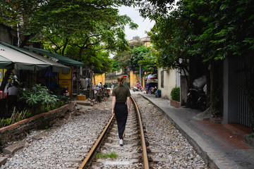 Fototapeta na wymiar woman walking on the railroad tracks in an urban environment