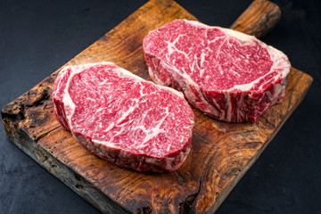 Rohes dry aged Wagyu Entrecote Steak vom Rind als closeup auf einem rustikalen Holz Board 