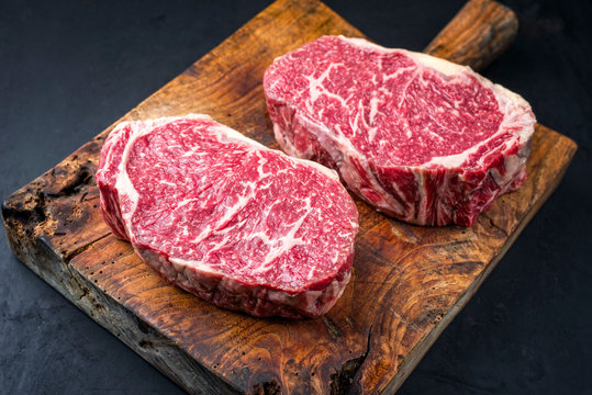 Rohes dry aged Wagyu Entrecote Steak vom Rind als closeup auf einem rustikalen Holz Board 