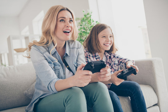 Photo Of Domestic Funny Blond Lady Mom Daughter Sitting Comfy Couch Hold Joystick Playing Video Games Stay Home Safety Quarantine Spend Weekend Together Best Friends Living Room Indoors