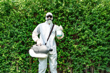 Professional technical man in prevention suit and black glasses with his sterilizing machine and disinfecting water in his hand. He is ready to take purifying coronavirus (COVID-19) out.
