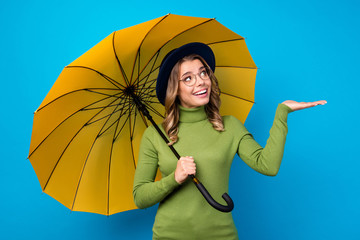 Photo of cheerful funny lady big umbrella walk street rainy spring check hand catch drops enjoy...