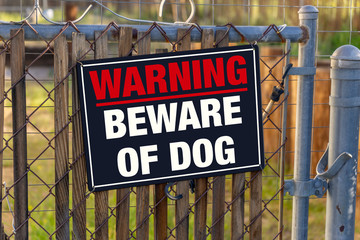 WARNING BEWARE OF DOG - sign on chain link fence.