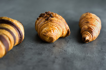 Photograph of three different kinds of traditional croissants recently baked, a delicious snack.