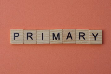 long word primary from gray wooden small letters with black font on an orange background