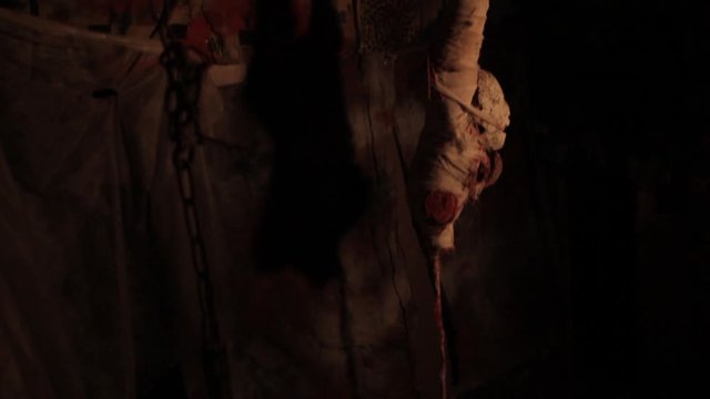 Silhouette of man maniac or killer or horror murderer with chainsaw in hand in dark creepy and spooky room. Criminal robber or rapist concept in thriller atmosphere with  victim girl