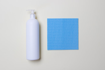 white bottle with cleaning agent and napkin on white background top view