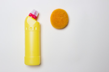 yellow bottle with cleaning agent and scrubber on white background  top view