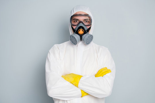 Photo of epidemic specialist professional guy disinfectant clean public places pandemic arms crossed wear white hazmat protective suit goggles mask hood gloves isolated grey color background